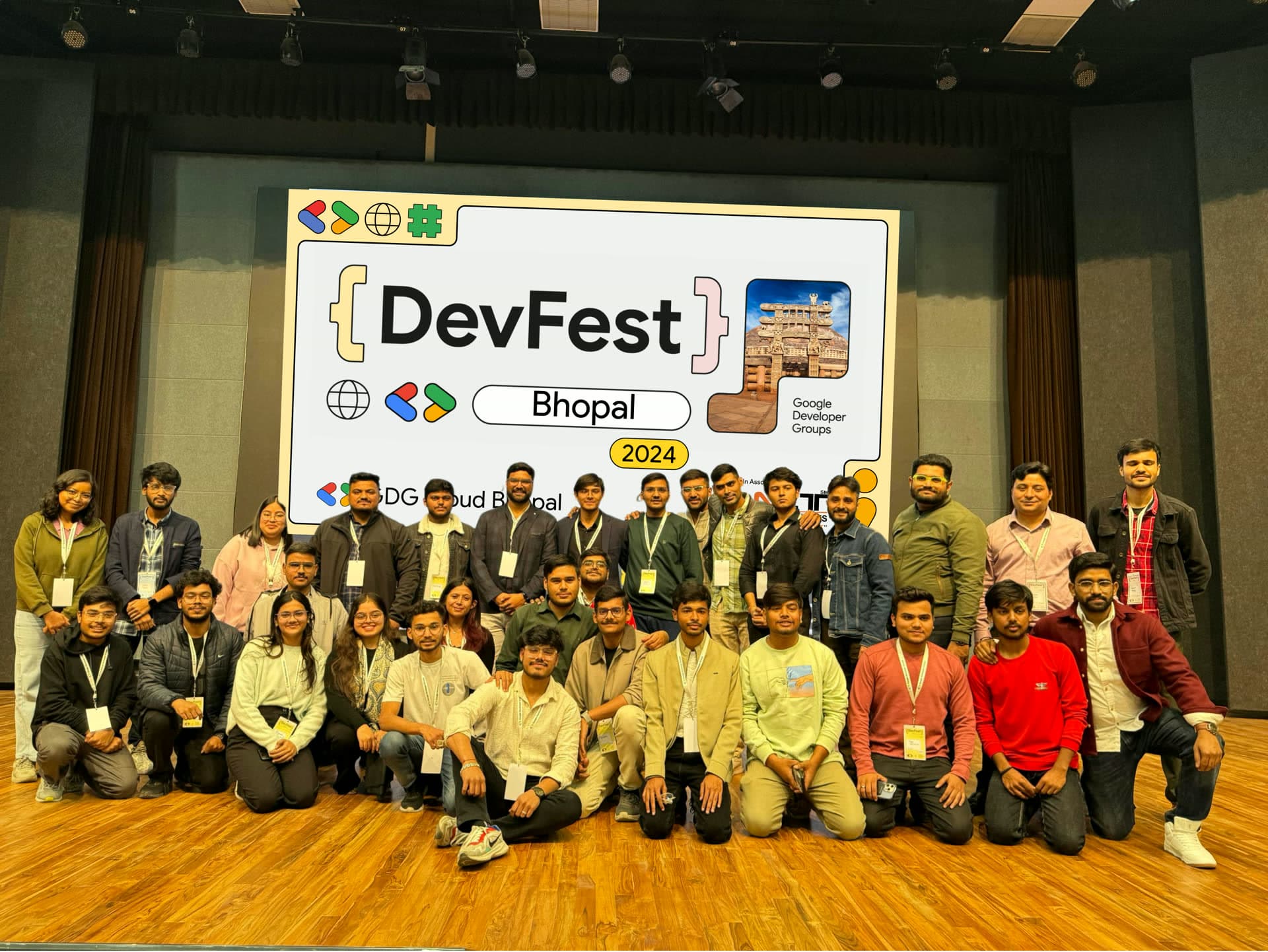 Full team of volunteers and organizers gathered on stage in front of the DevFest Bhopal 2024 LED backdrop